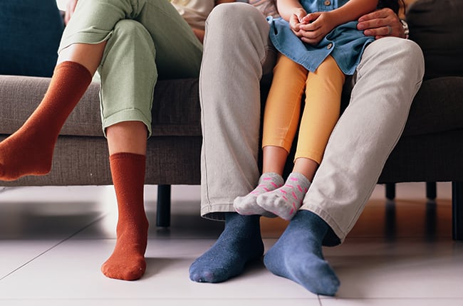 양말을 신고 소파에 앉아 있는 가족의 발 확대 모습